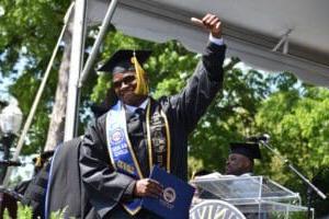 Student holding diploma smiling